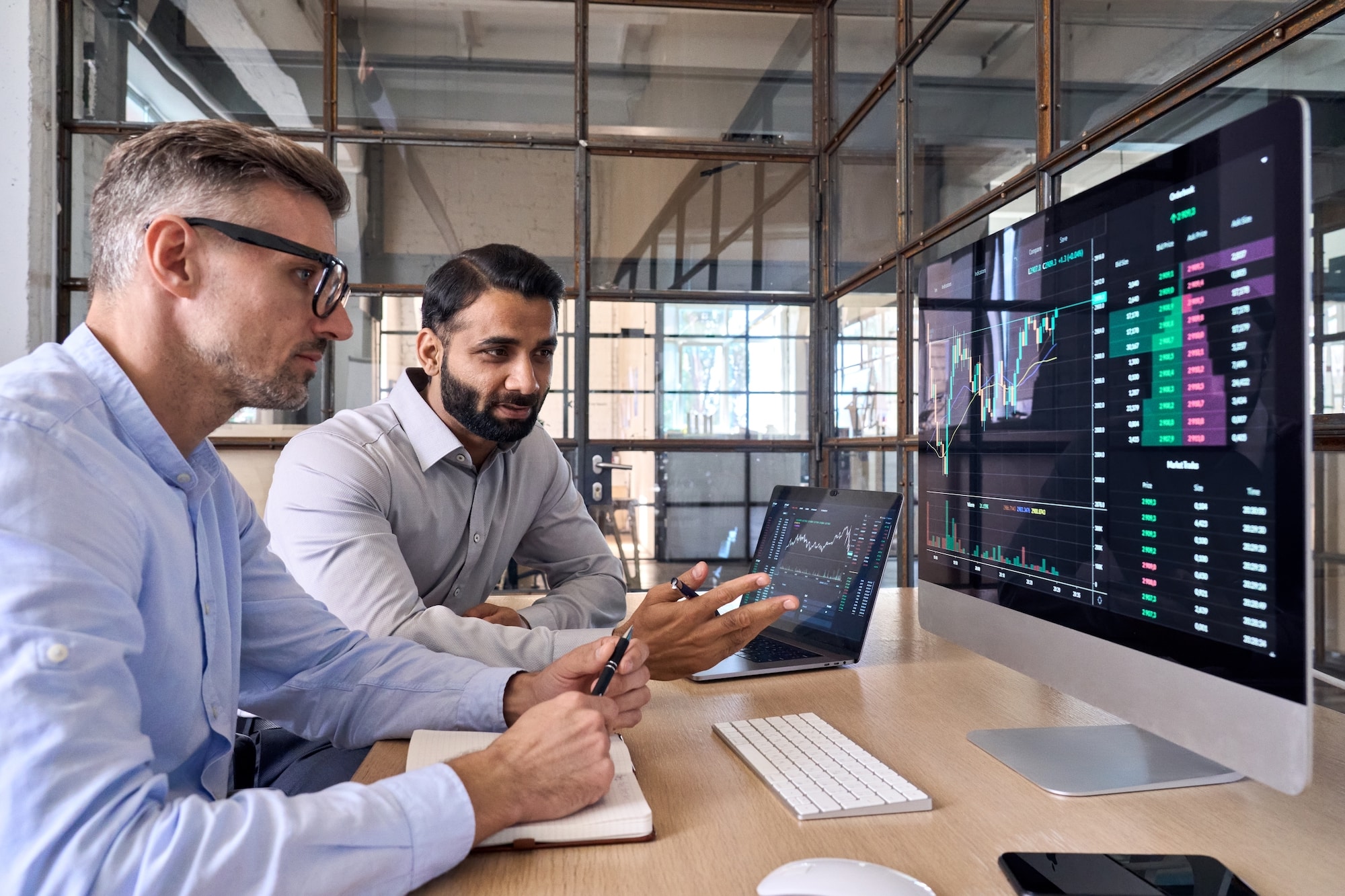 two people discussing when to sell restricted stock at a computer